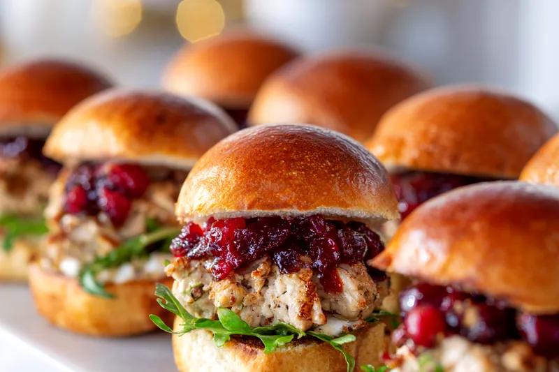 Fresh ingredients for turkey cranberry sliders on a cutting board